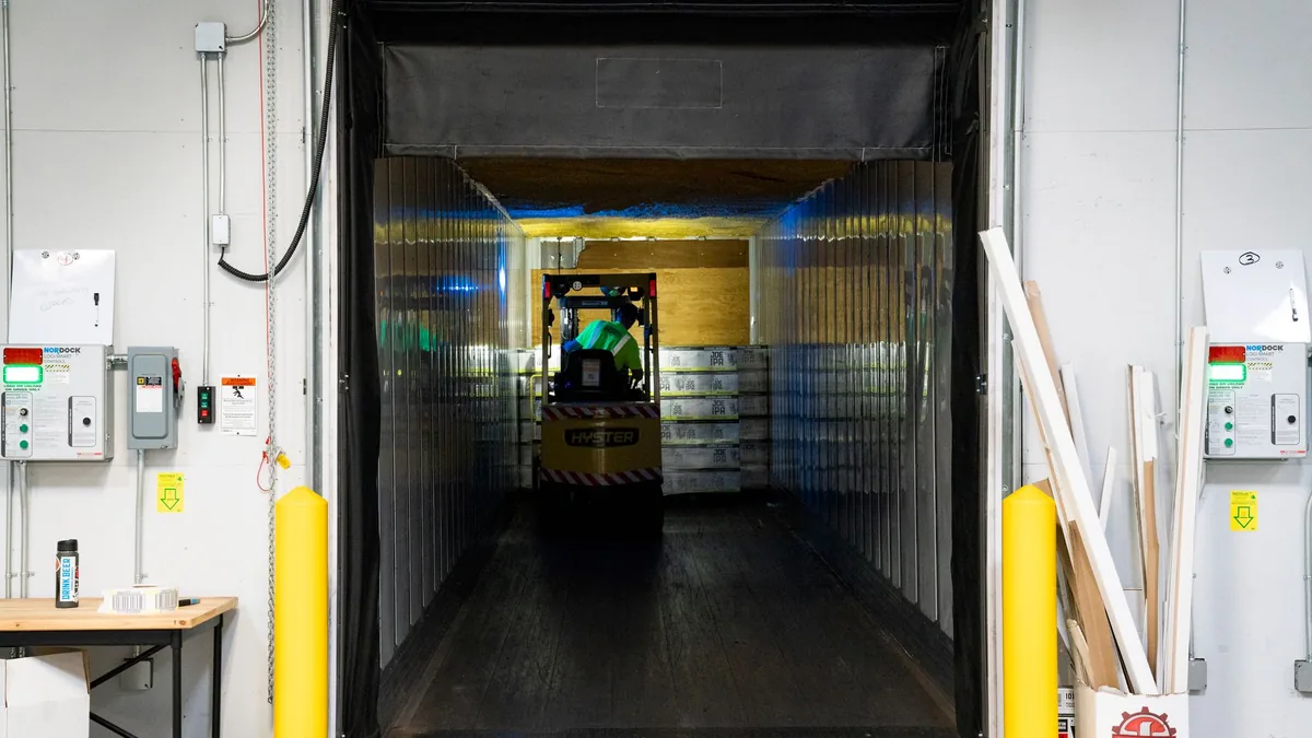 Vista desde el andén hacia el interior de la caja de un camión durante la carga