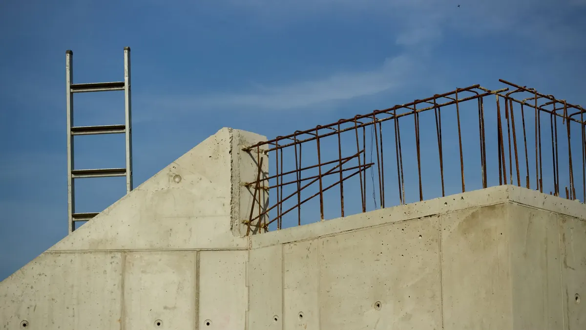 Castillo y dala de concreto con varilla en espera sobre un muro perimetral